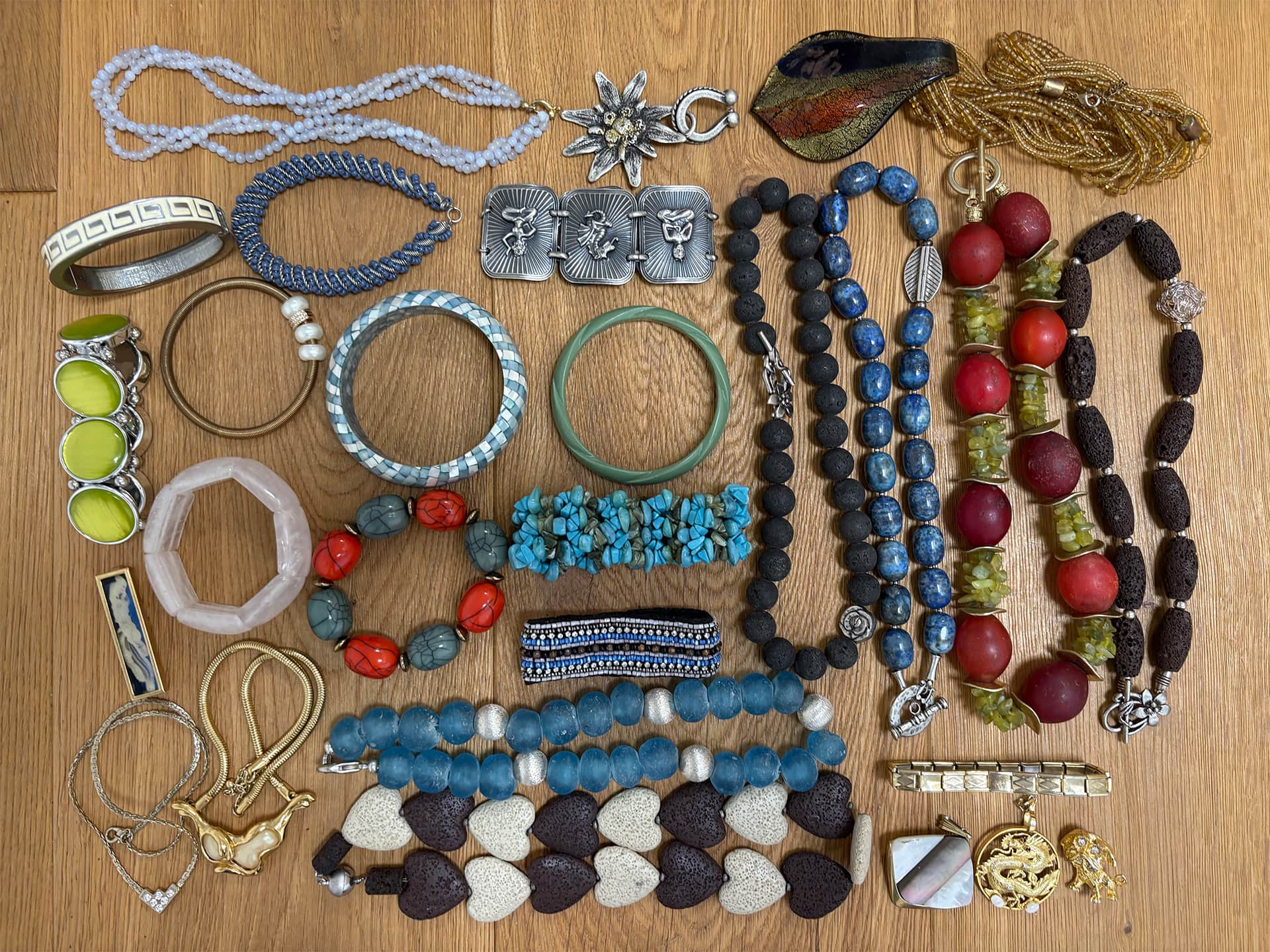 Modeschmuck mit Armreifen und Perlenketten auf einem Holztisch