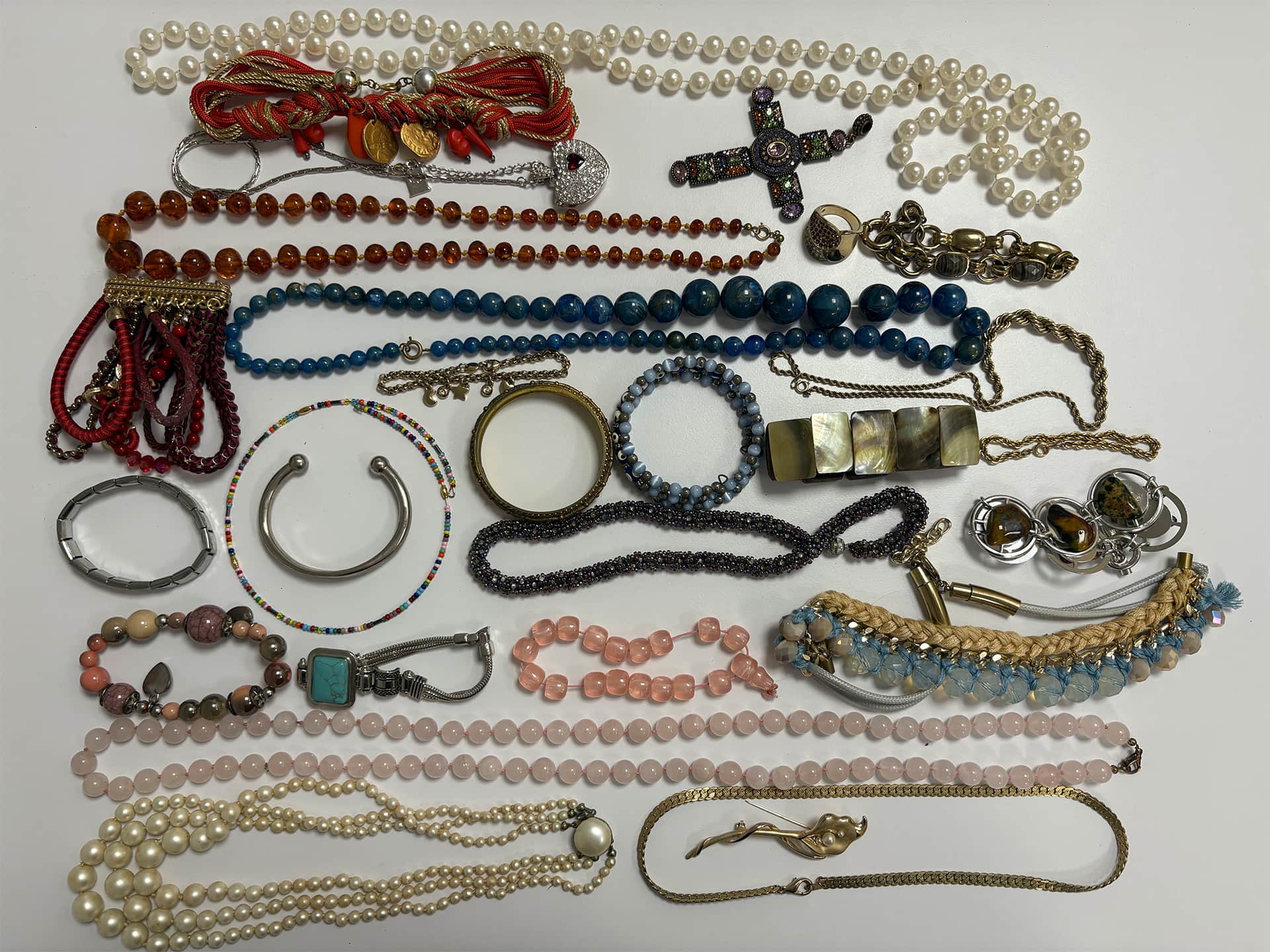 Sonstiger Schmuck: Ketten, Armreifen und Perlenketten nebeneinander gelegt